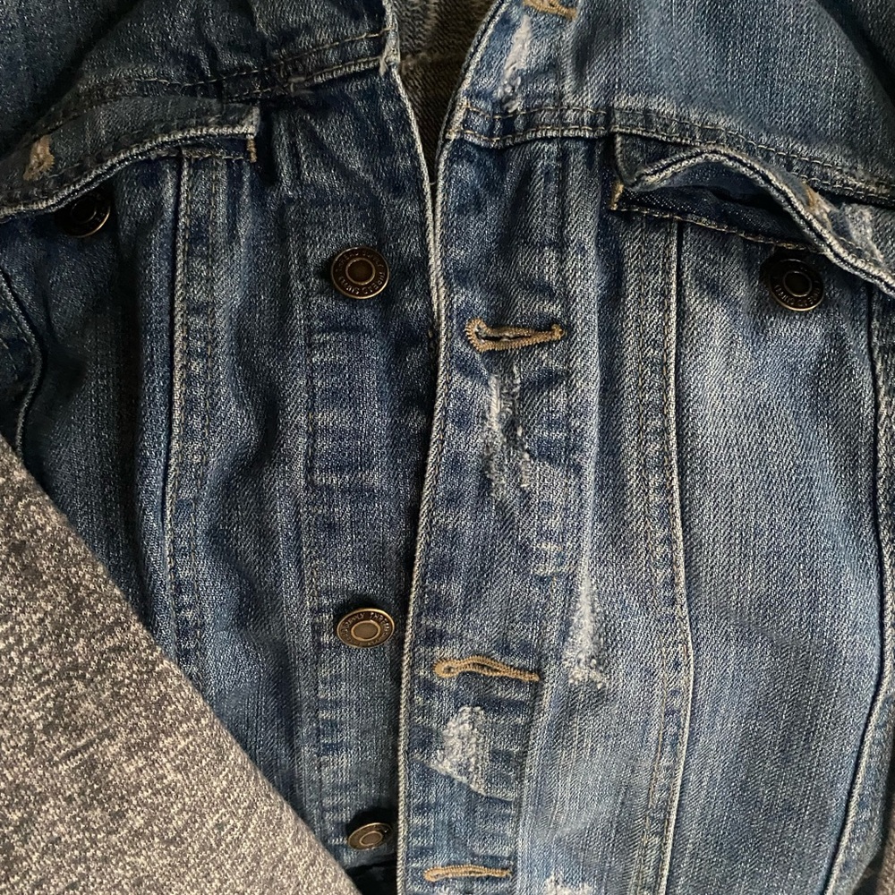Thread and Supply Jean jacket with grey sweatshirt hood and sleeves.